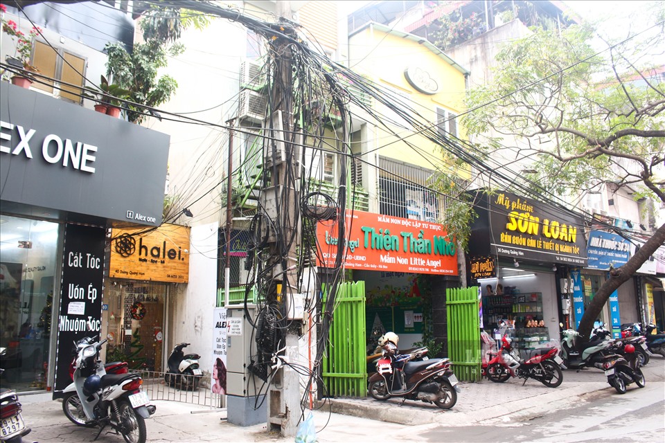Ghi nhận của PV tại phố Dương Quảng Hàm (quận Cầu Giấy), dây điện, cáp viễn thông ở đây “tụ” lại từng cột, rất lộn xộn và phản cảm.