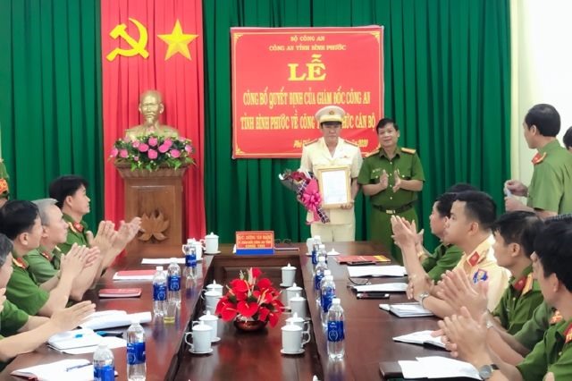 Đại tá Dương Văn Mạnh trao quyết định điều động và tặng hoa chúc mừng Thượng tá Mai Văn Thanh. Ảnh VGP