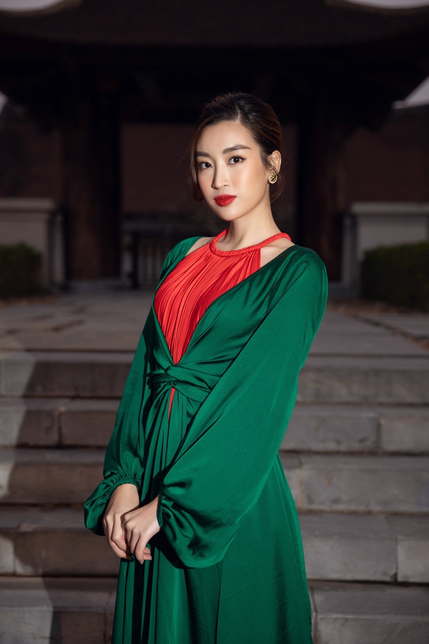 Hoa hậu Mỹ Linh tựa một nàng 'ả đào' quyến rũ với bộ váy yếm màu đỏ, kết hợp cùng áo choàng xanh.