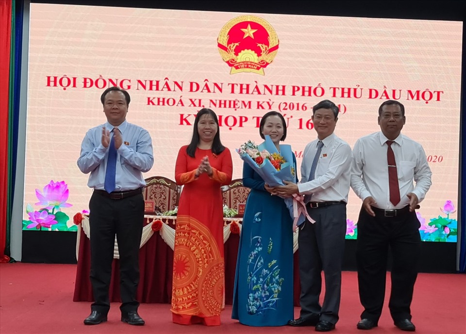 Ông Võ Văn Minh - Chủ tịch HNĐNĐ tỉnh Bình Dương tặng hoa chúc mừng bà Nguyễn Thu Cúc. Ảnh: Dương Bình