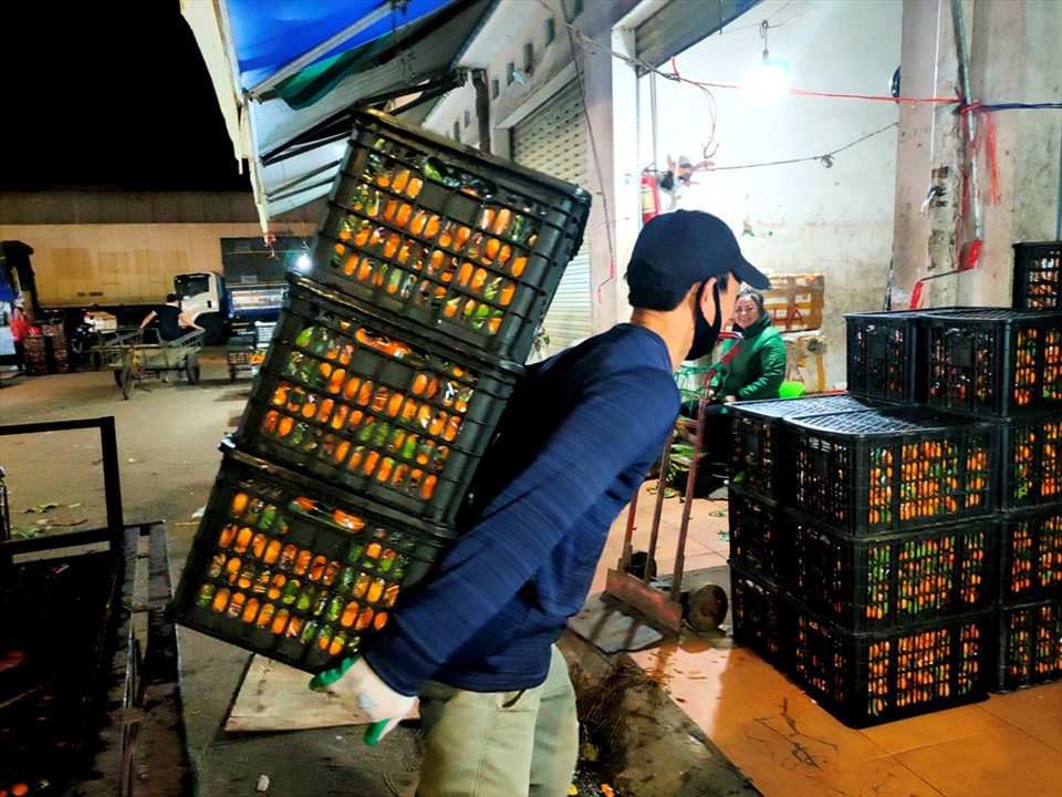 Khuya ngày 18.12, tại chợ đầu mối Đông Hương, hàng trăm cửu vạn vẫn hăng say làm việc trong tiết trời lạnh giá. Ảnh: Quách Du
