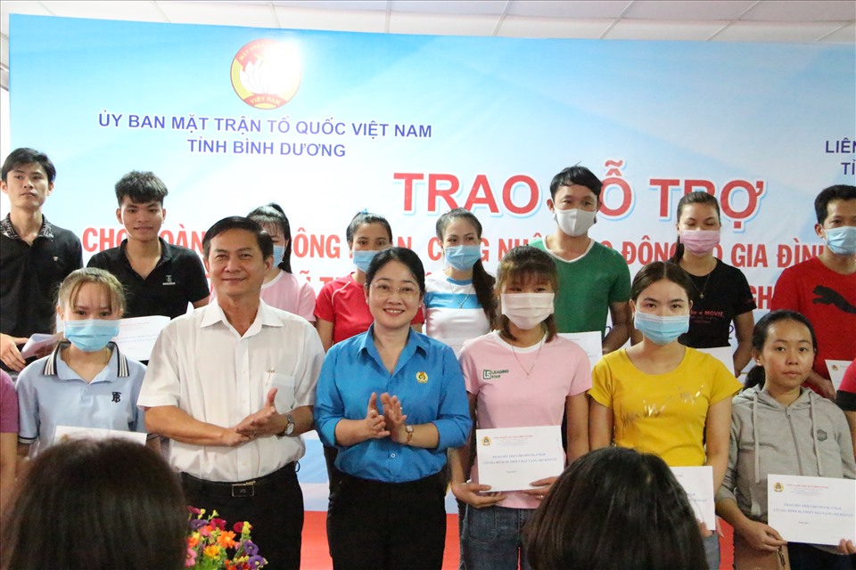 Ông Nguyễn Văn Lộc (hàng đầu, thứ 2 từ trái sang) cùng bà Nguyễn Kim Loan trao hỗ trợ cho công nhân ở công ty