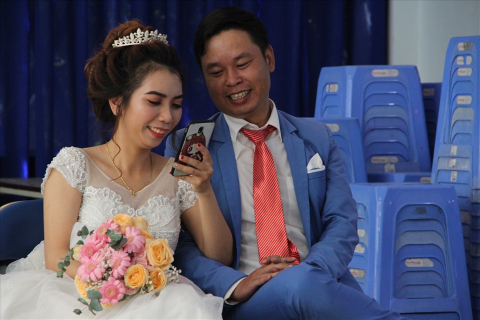 Cặp đôi Bùi Thanh Sơn và Nguyễn Minh Tâm hạnh phúc ngồi bên nhau trong đám cưới tập thể. Ảnh: Đình Trọng