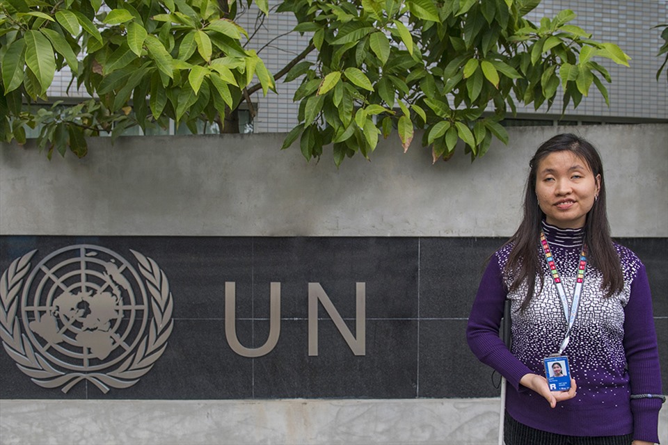 Hương tự hào là cán bộ của UNDP bên logo của Liên hiệp quốc tại Tòa nhà Xanh Một Liên hiệp quốc.