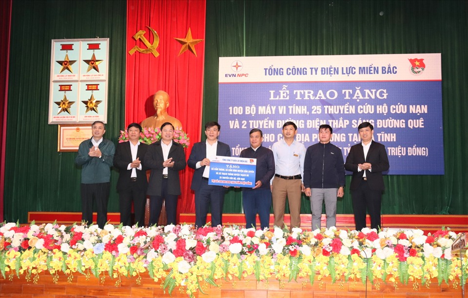 Ông Lê Văn Trang - Phó Tổng giám đốc EVNNPC (thứ 4 từ trái sang) trao tặng 25 thuyền cứu hộ cho các xã trên địa bàn huyện Cẩm Xuyên. Ảnh: EVNNPC