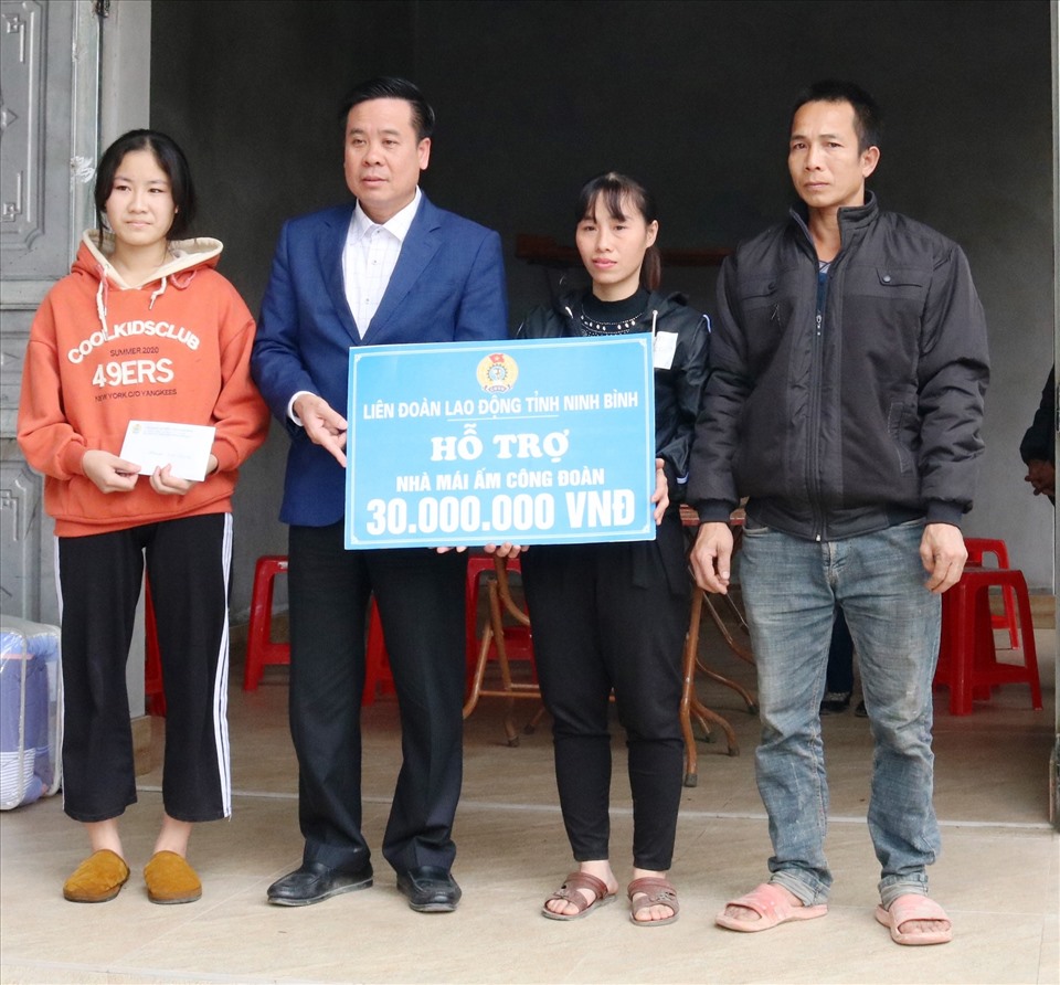 Ông Dương Đức Khanh, Chủ tịch LĐLĐ tỉnh Ninh Bình trao tiền hỗ trợ cho gia đình chị Vũ Thị Giáp. Ảnh: NT