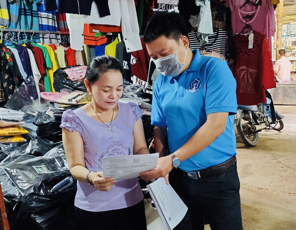 Cán bộ Bảo hiểm xã hội Khánh Hoà tuyên truyền về BHXH tự nguyên cho tiểu thương chợ Vĩnh Lương (Tp.Nha Trang). Ảnh:Phương Linh