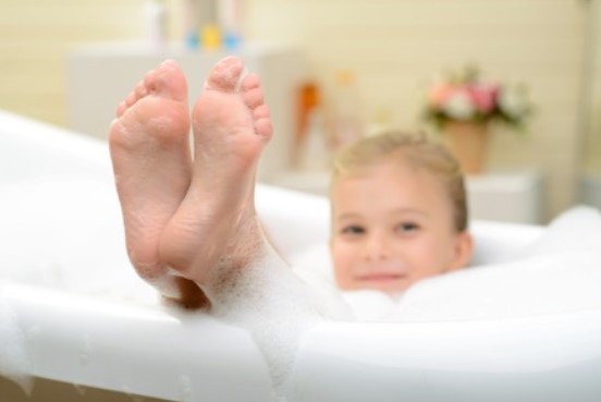 Dạy các bé massage phần gót chân khi tắm sẽ giúp đảm bảo được sức khỏe. Ảnh nguồn: Xinhua.