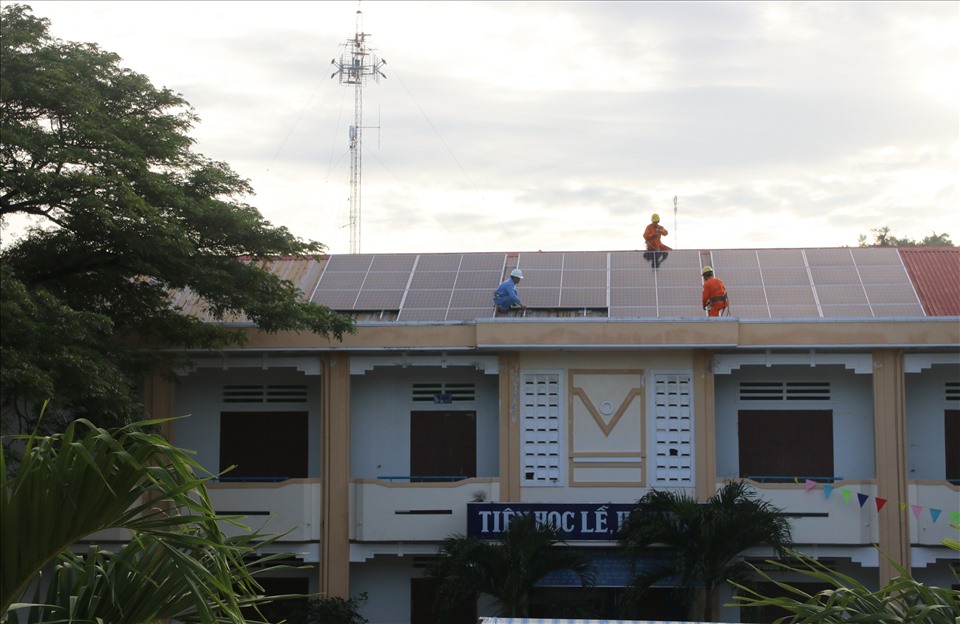 Đội ngũ kỹ thuật kiểm tra lại hệ thống điện mặt trời trên mái trước khi bàn giao cho trường THCS Trần Quang Khải. Ảnh: Phương Linh