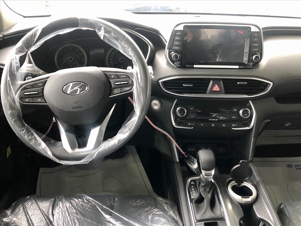 Vô lăng Hyundai SantaFe 2020 thiết kế 3 chấu bọc da, được tích hợp đầy đủ các phím chức năng như điều chỉnh âm thanh, đàm thoại rảnh tay, Cruise Control, lẫy chuyển số… Cụm đồng hồ của 4 phiên bản cao cấp dùng màn hình 7 inch, 2 bản tiên chuẩn dùng màn hình 3,5 inch.  Cả 6 phiên bản đều trang bị màn hình cảm ứng 8 inch hỗ trợ kết nối Bluetooth, AUX, Radio, MP4, Apple CarPlay, hệ thống dẫn đường phát triển riêng ở thị trường Việt Nam; hệ thống âm thanh 6 loa Arkamys Premium Sound.
