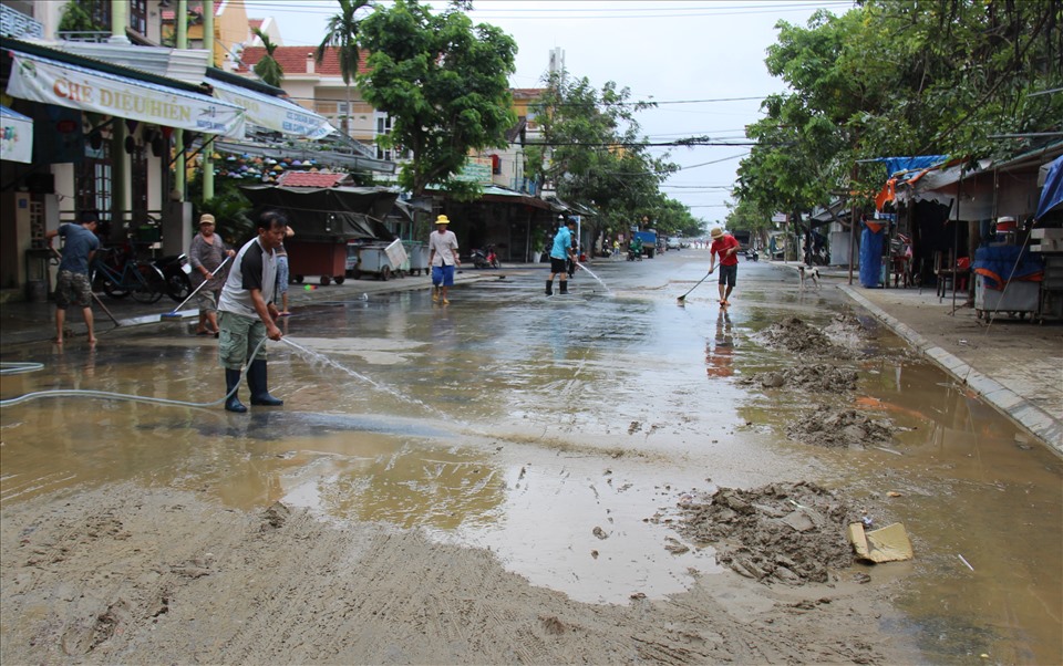 Nhiều người dân sống trên đường Nguyễn Hoàng nhanh chóng thu gom lớp bùn non dày đặc để vận chuyển đi nơi khác.