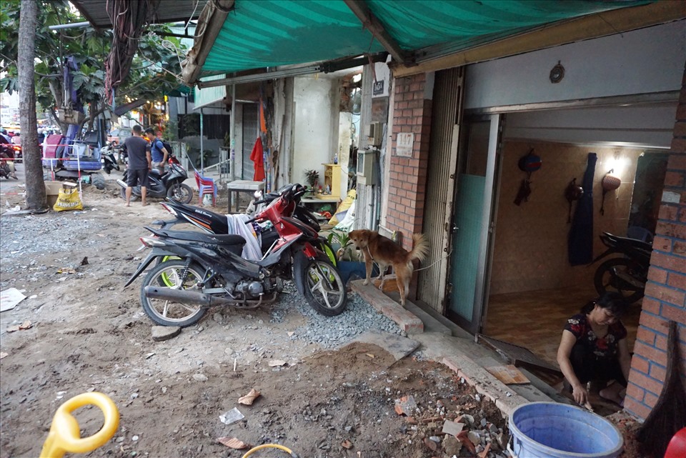Để thuận tiện đi đi lại, nhiều hộ dân trên đường Nguyễn Hữu Cảnh phải xây các bậc tam cấp để dắt xe ra vào.