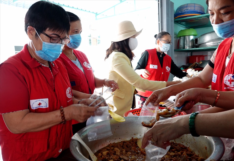Bà Trần Thị Tuyết (bên trái) tất bật chuẩn bị bữa ăn cho các bệnh nhân nghèo. Ảnh: A.T