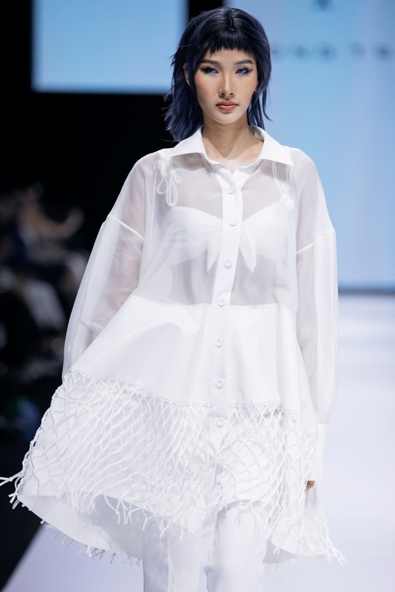 Hoàng Thùy trình diễn mẫu áo sơmi oversized xuyên thấu, phần vạt áo cách điệu mặt lưới.