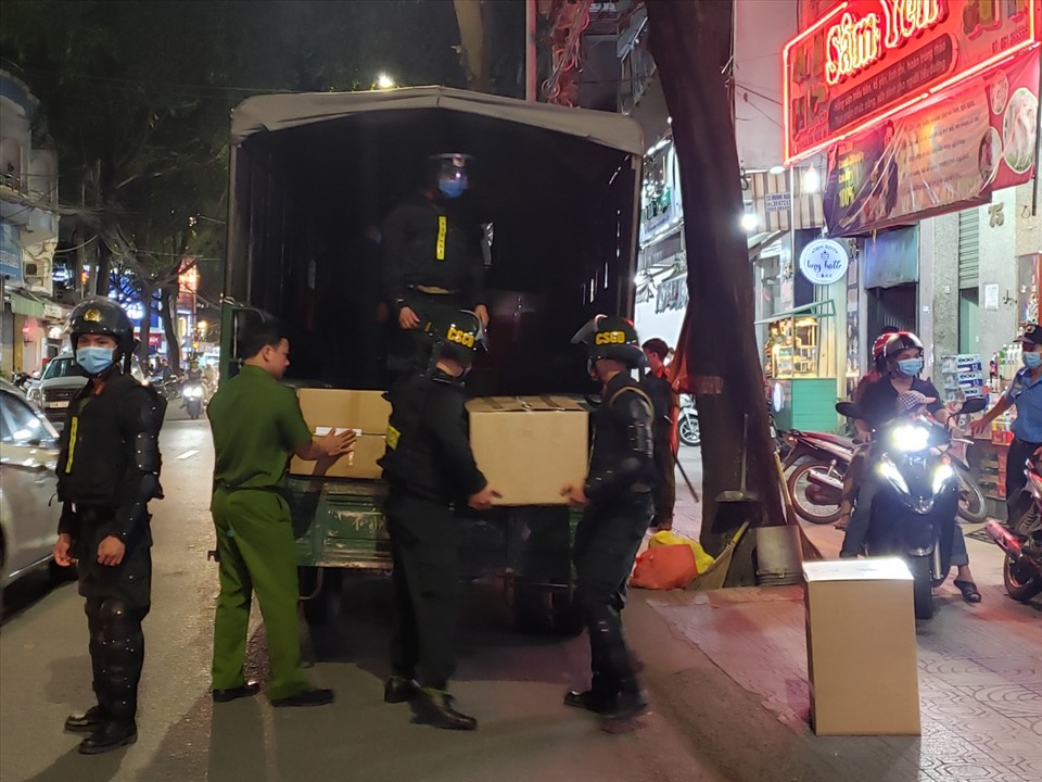 Lực lượng công an phối hợp với lực lượng Cảnh sát cơ động vận chuyển các thùng thuốc bị tạm giữ ra xe công vụ, phục vụ công tác điều tra. Ảnh: Hà Anh Chiến