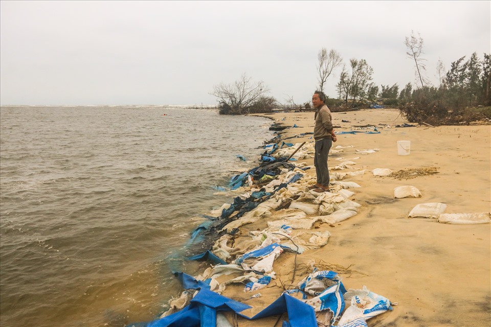 Ông Phạm Văn Châu đang đứng trên số tài sản hàng trăm triệu đồng bị nước cuốn trôi, và vùi lấp ở Cửa Lở trong cơn bão số 9 vừa qua.