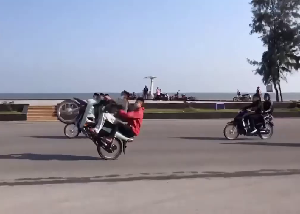 Nhóm thanh niên thi nhau bốc đầu xe máy trên đường bờ biển Sầm Sơn. Ảnh: Cắt từ Clip