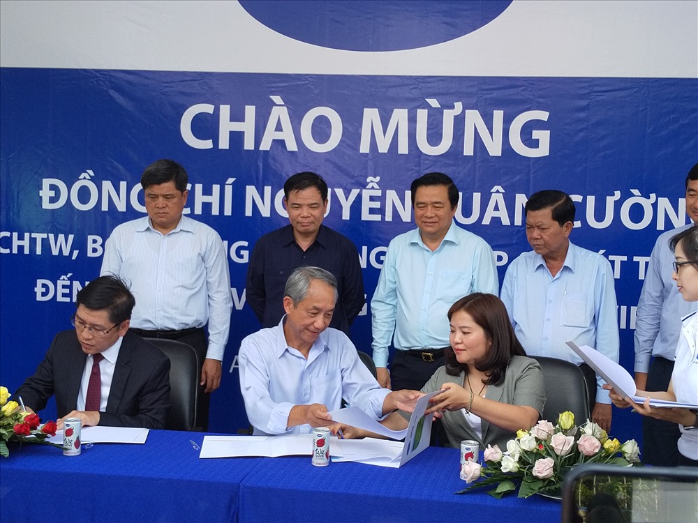 Bộ trưởng Nguyễn Xuân Cường (dứng, áo sậm) chứng kiến ký kết tiêu thụ giữa doanh nghiệp và nông dân trồng thanh long. Ảnh: K.Q