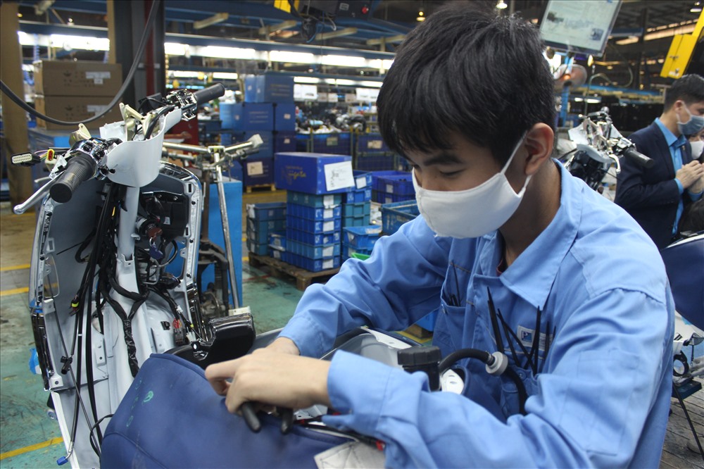 Công nhân Công ty TNHH Piagio Việt Nam đeo khẩu trang trong khi làm việc.