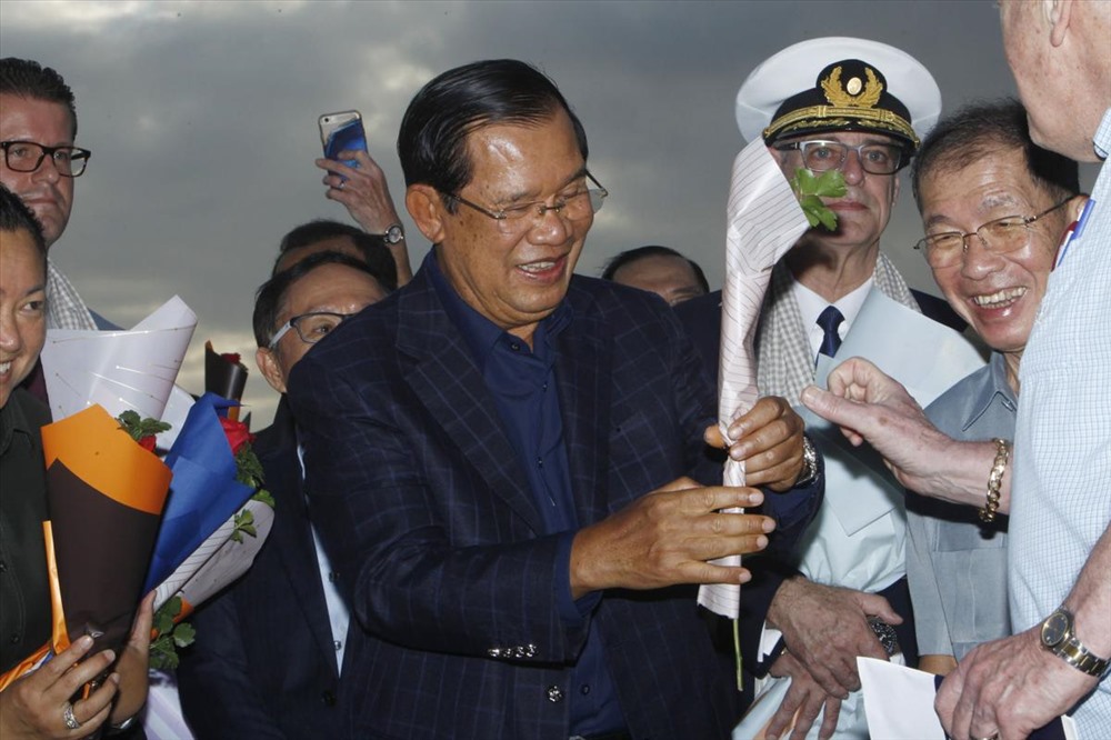 Thủ tướng Campuchia  Hun Sen tặng hoa cho một hành khách xuống tàu MS Westerdam. Hôm 13.2, Thủ tướng Hun Sen đã đồng ý cho tàu MS Westerdam cập cảng Sihanoukville sau khi Thái Lan, Nhật Bản, Đài Loan (Trung Quốc), Philippines và đảo Guam Mỹ) từ chối tiếp nhận. Ảnh: ABP.