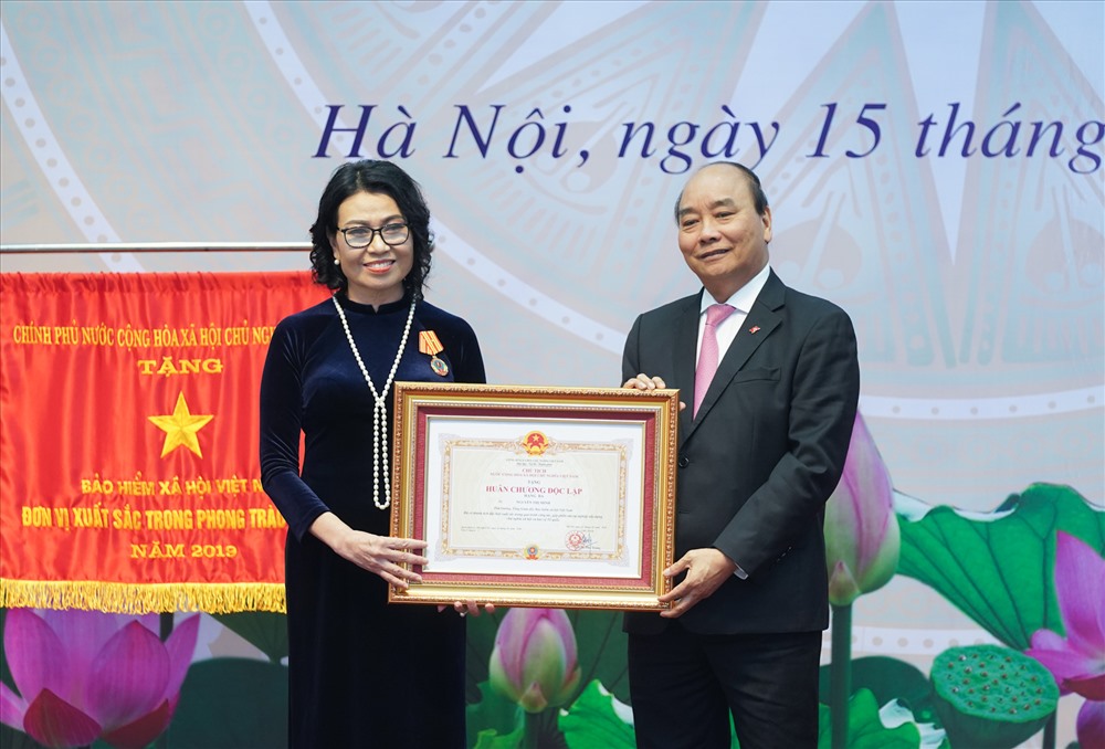 Thủ tướng trao Huân chương Độc lập hạng Ba cho TGĐ BHXH Việt Nam Nguyễn Thị Minh. Ảnh: VGP/Quang Hiếu