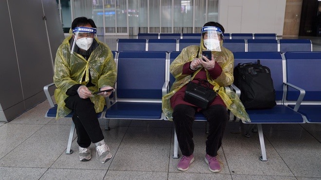 Người dân Bắc Kinh mặc áo mưa, đeo khẩu trang và mặt nạ nhựa tự chế. Ảnh: CNN.