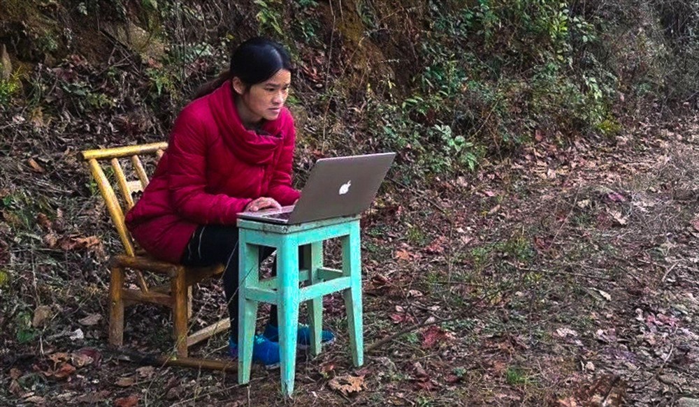 Cô Liêu Tiểu Lan đã tìm được 1 địa điểm gần nhà để dạy học trực tuyến cho học sinh bằng máy tính và cột thu sóng tự chế. Ảnh: SCMP