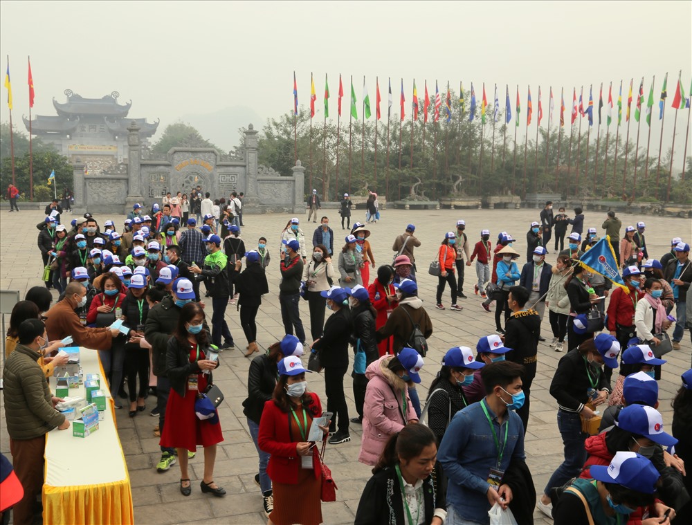 Nhiều du khách đi theo tour về, dù đã mang khẩu trang, nhưng vẫn được Ban quản lý chùa Bái Đính cấp thêm 1 khẩu trang dự phòng. Ảnh: NT