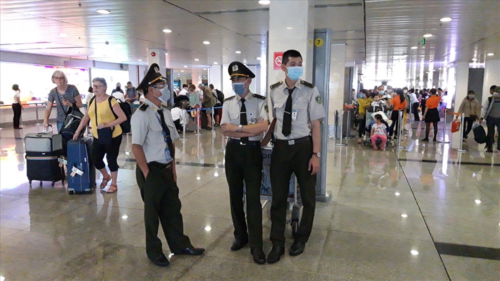 Tại khu vực cửa ra sân bay, đa số nhân viên an ninh đều tuân thủ việc đeo khẩu trang phòng ngừa dịch bệnh.