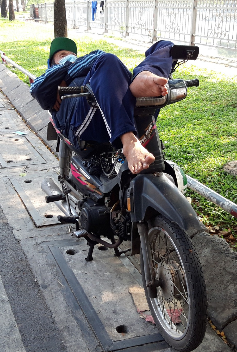 Chiếc xe máy không chỉ là phương tiện mưu sinh của người dân, mà còn là nơi nằm ngủ khá thuận tiện ở mọi lúc, mọi nơi. Ảnh TK.