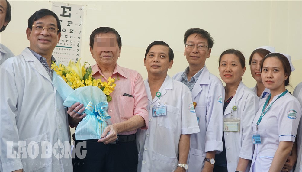 Chiều 21.2, nam bệnh nhân T.H.K (73 tuổi, quốc tịch Mỹ, người ôm bó hoa) nhiễm COVID-19, mừng rỡ khi được xuất viện. Ảnh: Hà Phương.