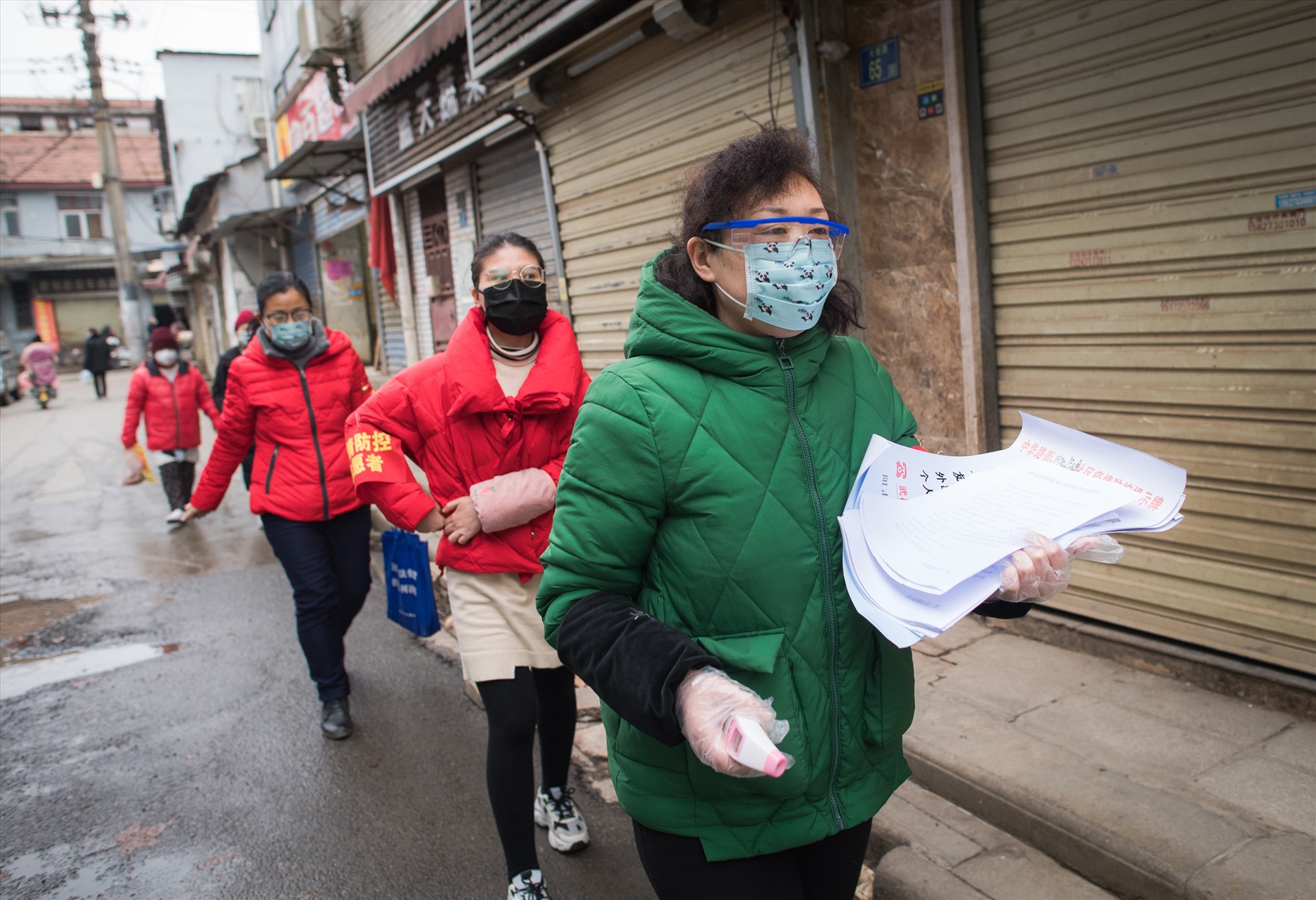 Nhân viên cộng đồng và tình nguyện viên chuẩn bị dán thông báo về phòng chống dịch bệnh tại Vũ Hán. Ảnh: Tân Hoa Xã.