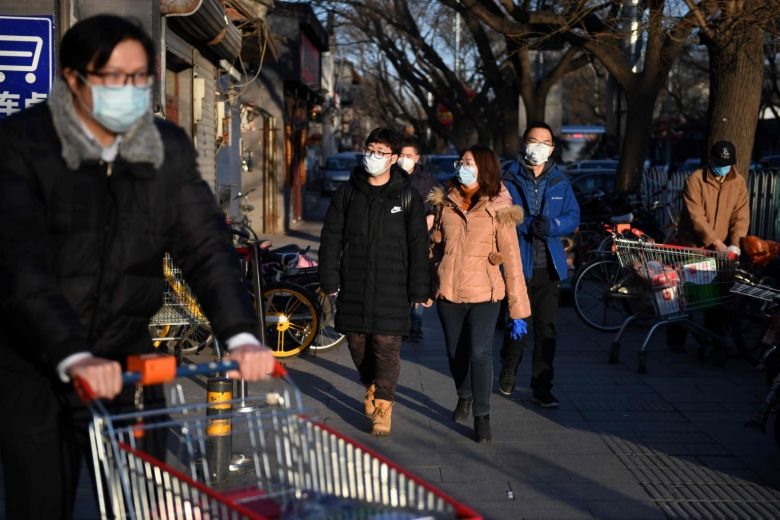 Người dân đeo khẩu trang khi đến một khu chợ ở Bắc Kinh. Ảnh: AFP