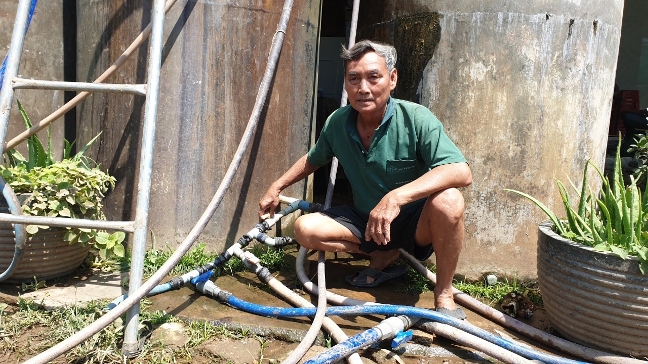 Một nông dân chuẩn bị đủ các đường ống bơm nước vào bể