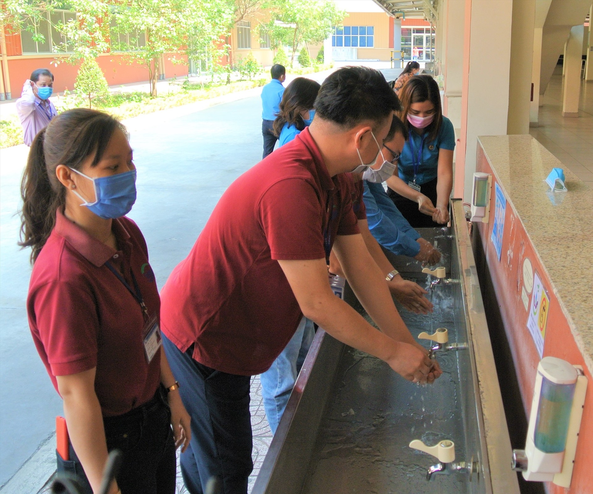 Đoàn giám sát và đại diện công ty cùng rửa tay tại nơi có trang bị nước sát khuẩn cho công nhân Công ty Worldon sử dụng. Ảnh Nam Dương