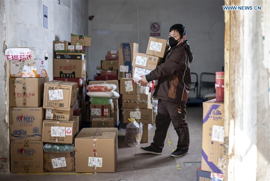 Lạc Tổng Bình là người quản lý một trạm giao hàng, anh đang sắp xếp các gói hàng tại một nhà kho ở Vũ Hán. Ảnh: Tân Hoa Xã