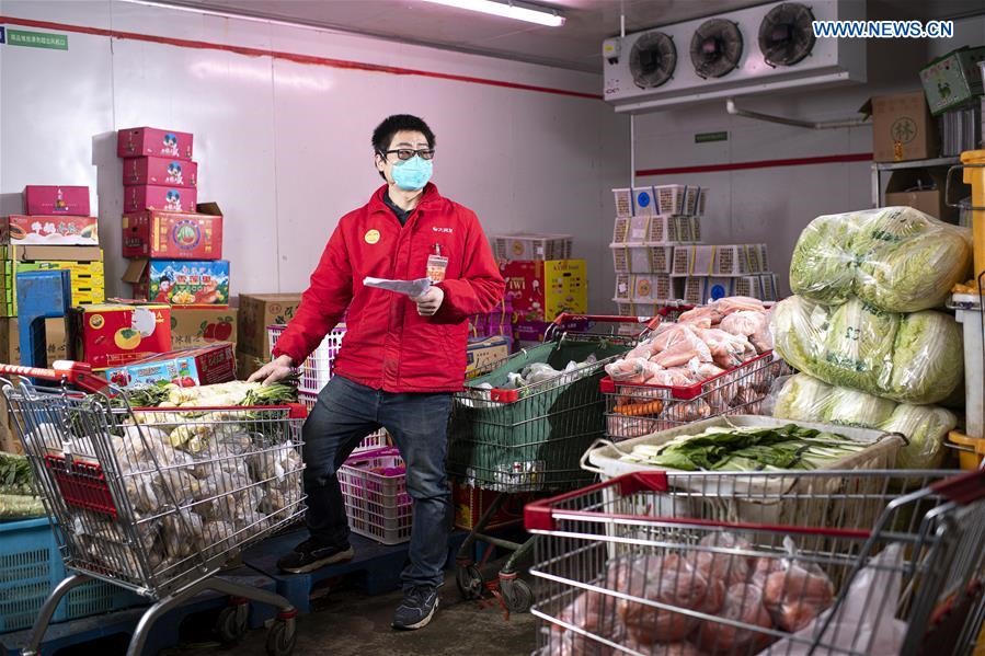 Người quản lý siêu thị Chu Duy  đang kiểm tra các mặt hàng tại siêu thị ở Vũ Hán. Trong thời gian dịch bệnh, nhu cầu tích trữ lương thực, thực phẩm của người dân tăng cao. Ảnh: Tân Hoa Xã