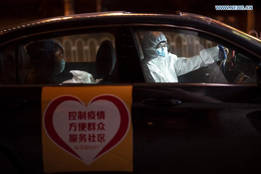 Lái xe Vương Vĩnh Bành đang chở hành khách ở Vũ Hán. Anh đã đăng ký làm tài xế tự nguyện chở nhân viên y tế từ nhà đến nơi làm việc của họ. Ảnh: Tân Hoa Xã
