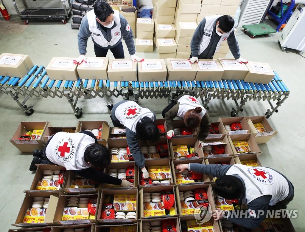 Công nhân Hội Chữ thập đỏ ở Suwon, cách Seoul 46 km về phía nam, chuẩn bị bộ dụng cụ cứu trợ khẩn cấp được đóng gói với các nhu yếu phẩm cơ bản, như thực phẩm ăn liền và nước đóng chai, để giao cho những người tự cách ly, vào ngày 28 tháng 2 năm 2020. (Yonhap)