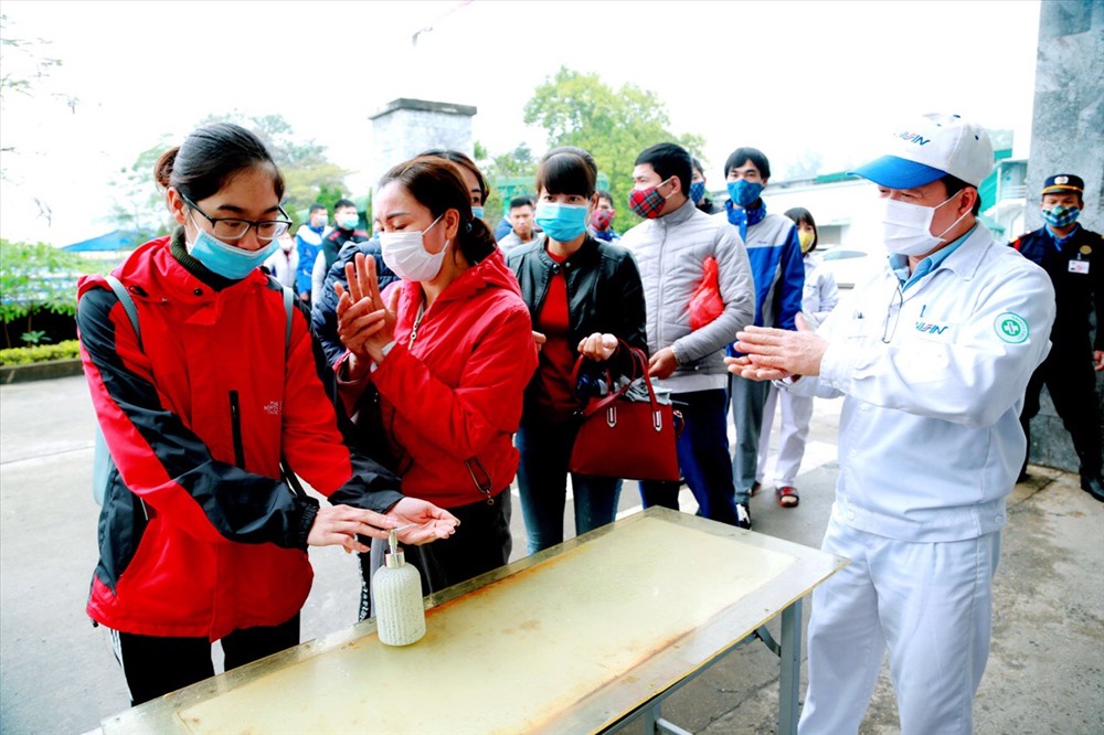 Công nhân công ty sản xuất phanh Nissin (Vĩnh Phúc) rửa tay sát khuẩn trước khi vào làm việc.