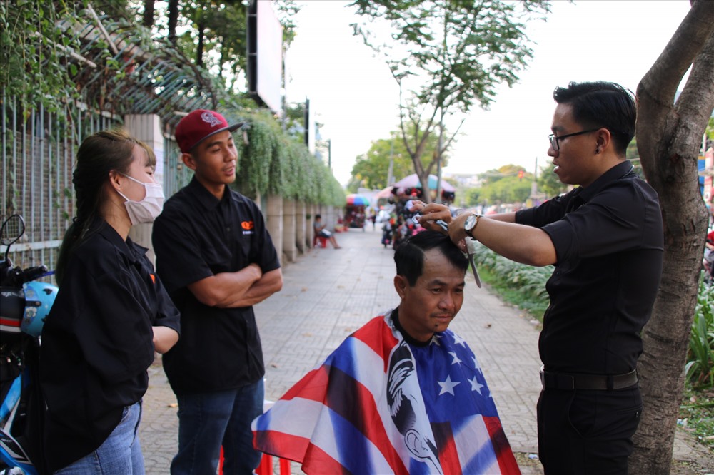 Trưởng nhóm Nguyễn Quốc Cường vừa cắt tóc cho khách, vừa hướng dẫn các bạn mới vào nghề. Ảnh TK.
