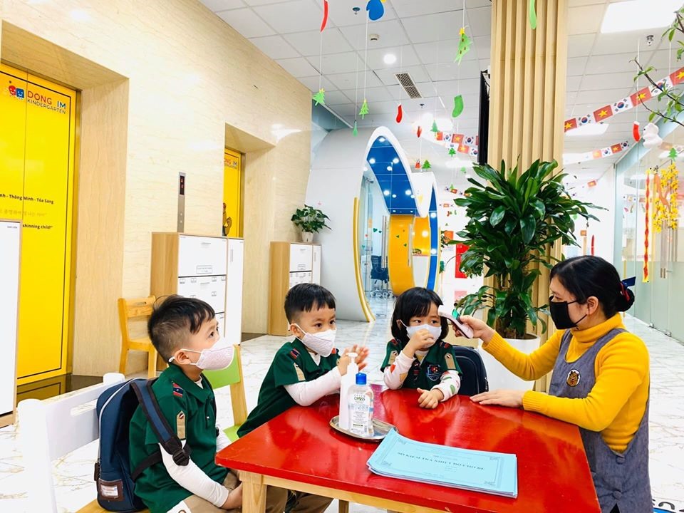 Giáo viên Trường mầm non Dongsim Kindergarten kiểm tra thân nhiệt và hướng dẫn học sinh vệ sinh phòng tránh dịch bệnh do virus Corona gây ra.