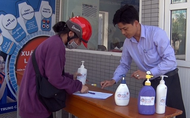 Người dân đến nhận dung dịch rửa tay diệt khuẩn do thầy trò Trường Cao đẳng Công nghiệp Huế pha chế đặt trước cổng trường ở số 70 đường Nguyễn Huệ (TP. Huế). Ảnh: DQT.