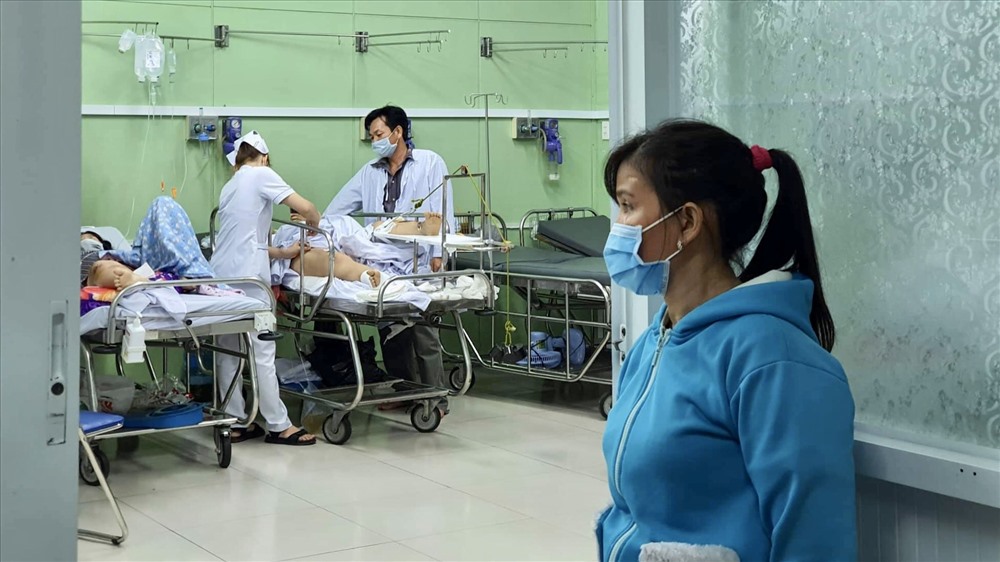 Bà Phạm Thị Kiều nhìn vào phòng Hồi sức cấp cứu khi các bác sĩ đang kiểm tra sức khoẻ cho chồng và con rể.