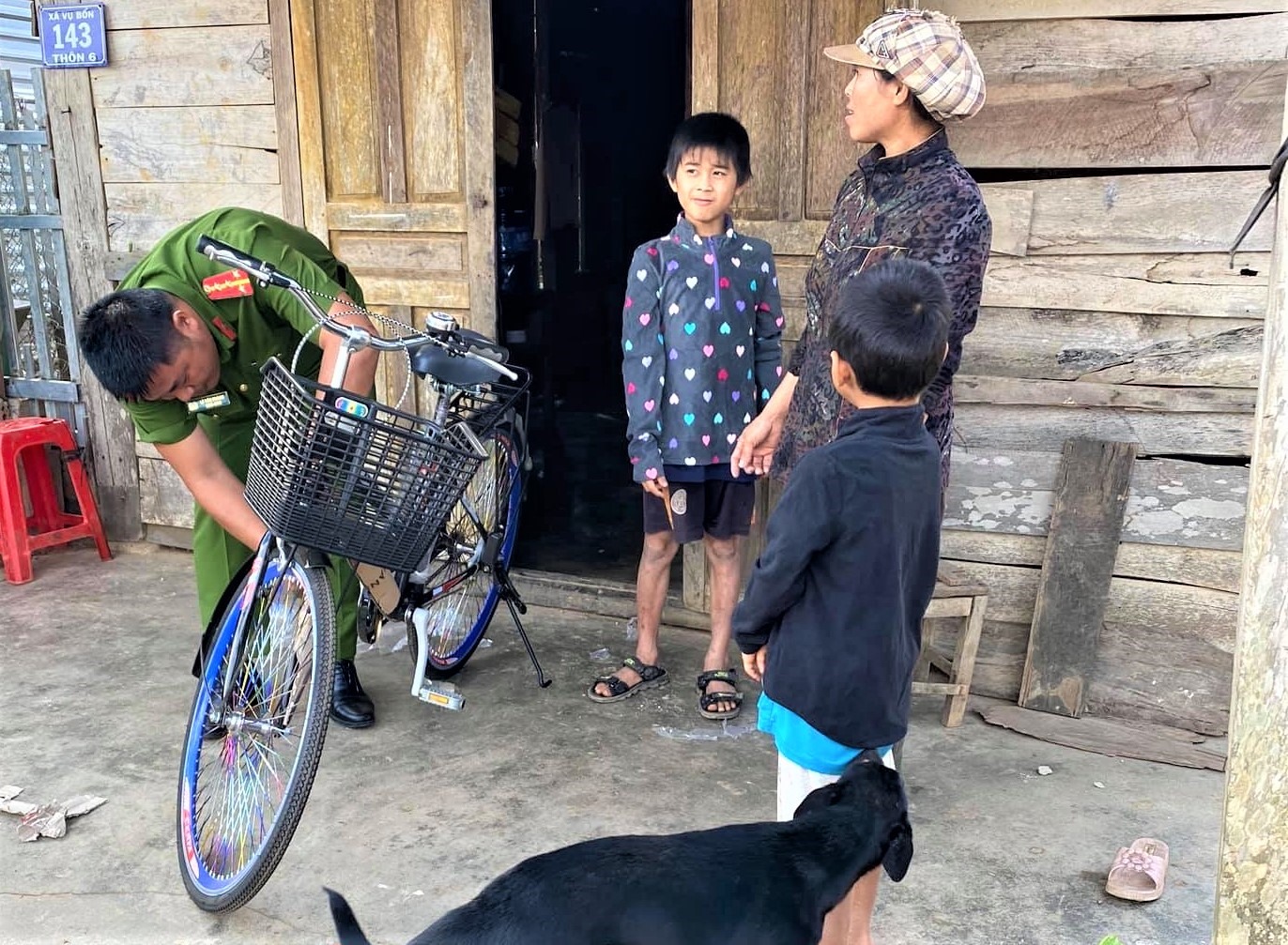 Đại úy Lê Tấn Thành trao xe đạp cho học sinh nghèo ở xã. Ảnh: Nhân vật cung cấp.