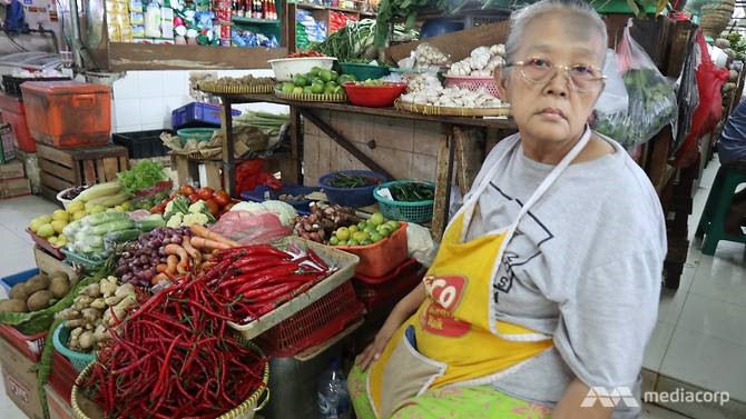 Bà Parinem, thâm niên bán rau 25 năm ở chợ, đang bán đắt hàng các loại thảo mộc tự nhiên. Ảnh: CNA