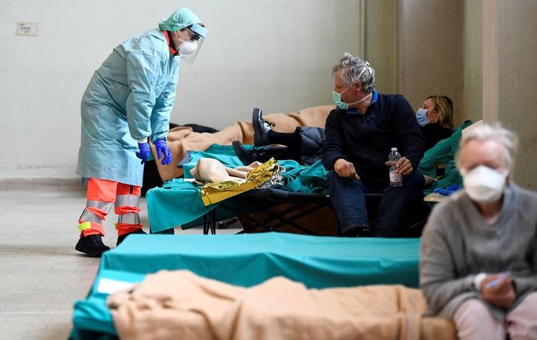 Nhân viên y tế giúp đỡ các bệnh nhân trong bệnh viện Spedali Civilili ở Brescia, Ý ngày 13 tháng 3. Các bệnh viện ở khu vực phía bắc của nước Ý đã phải gánh chịu hậu quả của bệnh truyền nhiễm, họ sắp hết không gian và thiết bị và nhân viên không được nghỉ ngơi trong nhiều tuần. REUTERS / Flavio Lo Scalzo