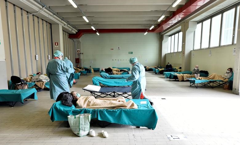 Nhân viên y tế mặc giúp bệnh nhân trong bệnh viện Spedali civili ở Brescia, Ý, ngày 13 tháng 3. Bệnh viện tại Brescia đã phải mở hai cánh đã bị đóng cửa để tái thiết nhằm đối phó với số lượng bệnh nhân đến điều trị. REUTERS / Flavio Lo Scalzo