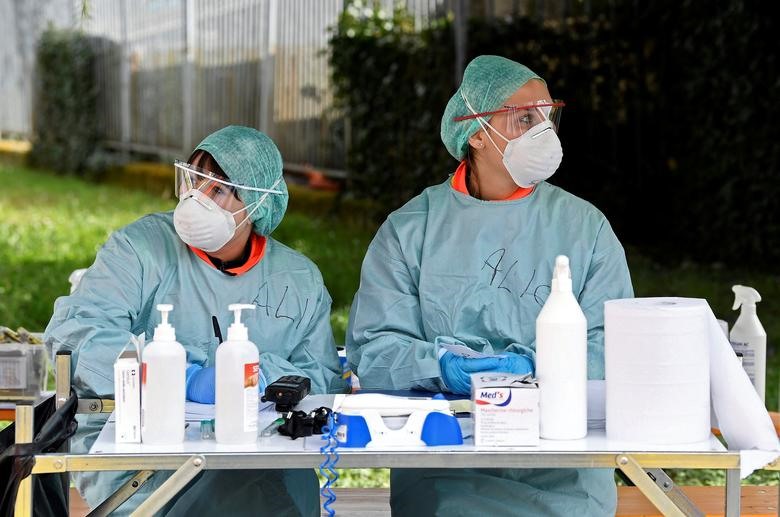 Nhân viên y tế đeo khẩu trang bảo vệ được nhìn thấy tại bệnh viện Spedali Civili ở Brescia, ngày 13 tháng 3. REUTERS / Flavio Lo Scalzo