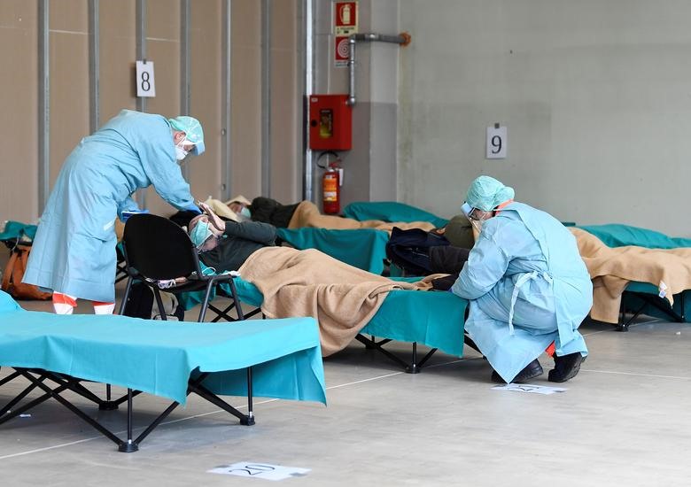 Nhân viên y tế giúp đỡ bệnh nhân trong bệnh viện Spedali Civilili ở Brescia, ngày 13 tháng 3. REUTERS / Flavio Lo Scalzo